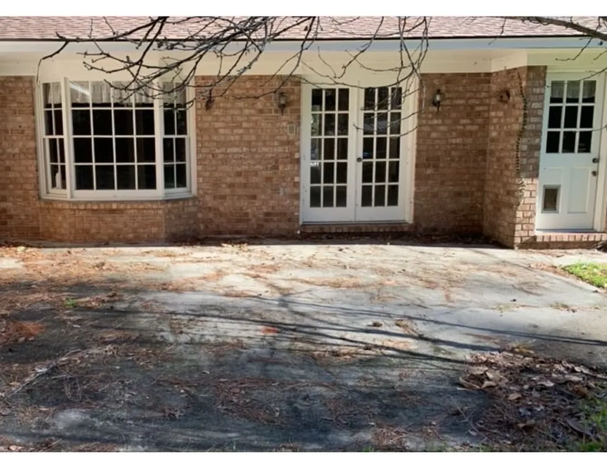 Lawn and beds covered in fallen leaves before removal